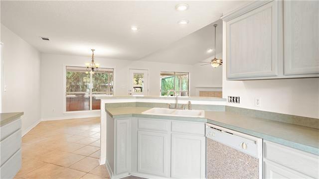70081 9th St, Covington, LA 70433 - kitchen featuring white dishwasher, a sink, a peninsula, light tile patterned floors, and decorative light fixtures