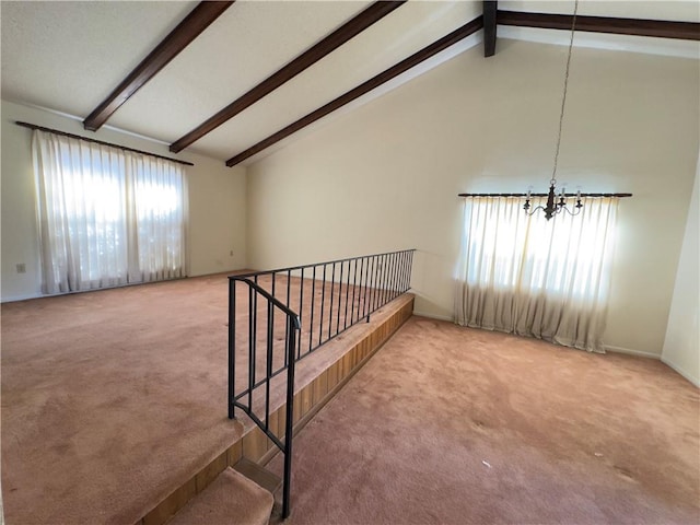 carpeted spare room with vaulted ceiling with beams and an inviting chandelier