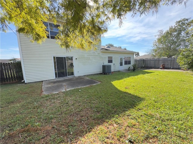 rear view of house featuring cooling unit, a yard, and a patio