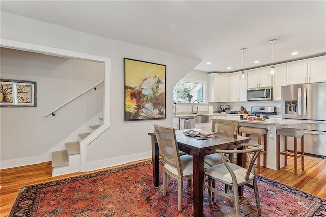 dining space featuring sink and light wood-type flooring