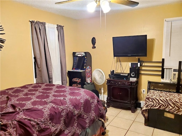 bedroom with ceiling fan, light tile patterned floors, and a textured ceiling