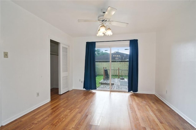 spare room featuring baseboards, a ceiling fan, and light wood-style floors