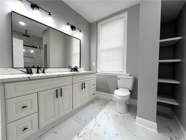 bathroom with a tile shower, vanity, and toilet