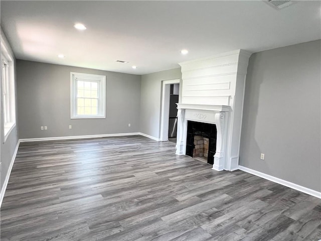 unfurnished living room featuring hardwood / wood-style flooring and a large fireplace