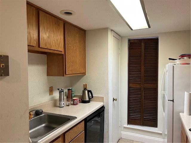 kitchen with sink, white fridge, and black dishwasher