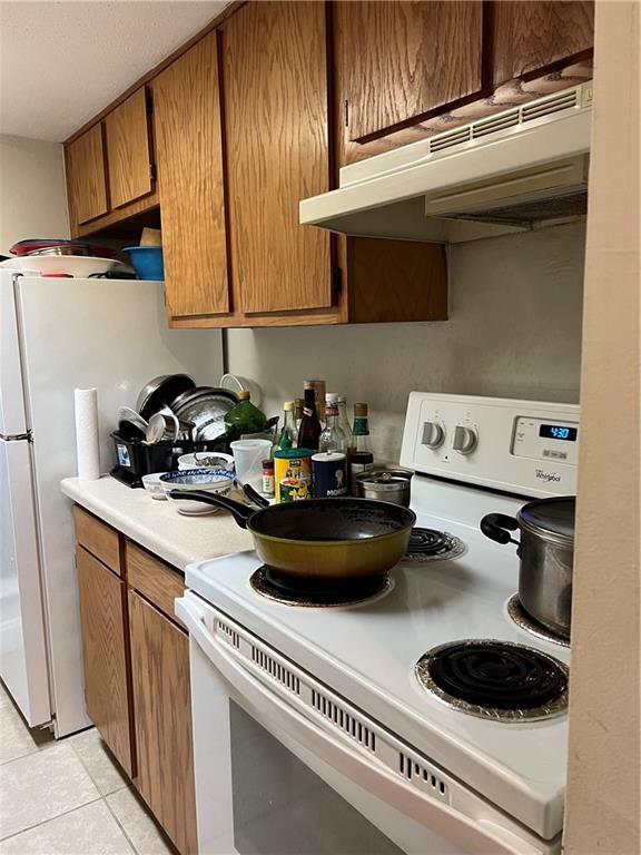 kitchen featuring light tile patterned floors and white appliances