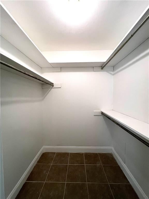 spacious closet featuring dark tile patterned flooring