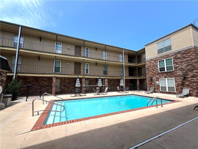community pool featuring fence and a patio area