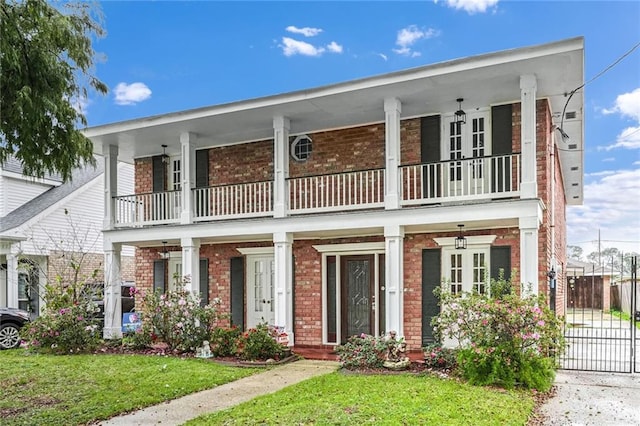 view of front of property with a balcony and a front lawn