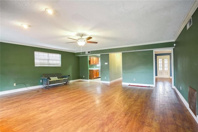 empty room featuring wood-type flooring, a textured ceiling, and a wealth of natural light