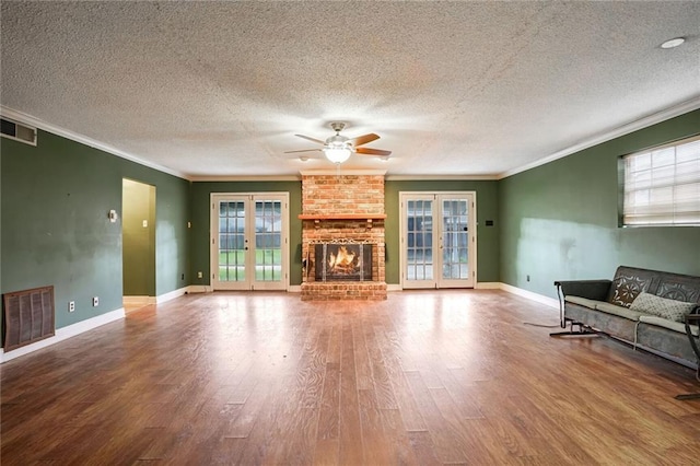 unfurnished living room with crown molding, french doors, wood-type flooring, and a textured ceiling