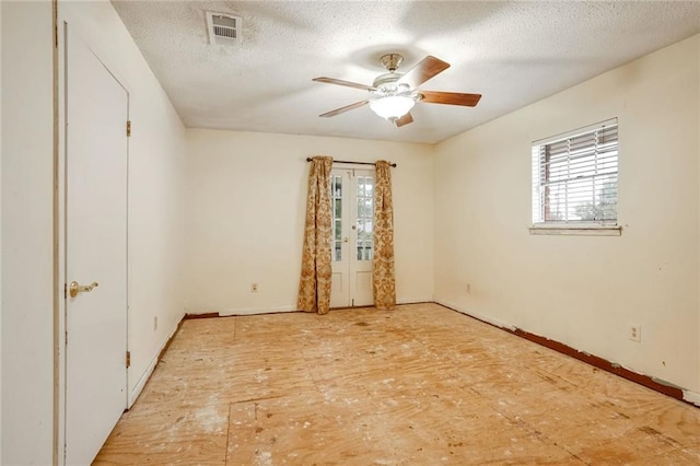 unfurnished room featuring ceiling fan and a textured ceiling