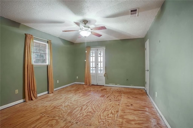 empty room featuring vaulted ceiling, ceiling fan, a textured ceiling, and light wood-type flooring