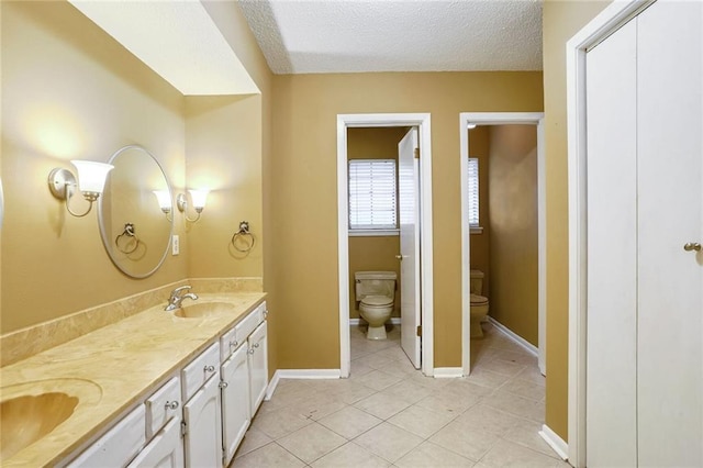 bathroom featuring tile patterned floors, vanity, a textured ceiling, and toilet