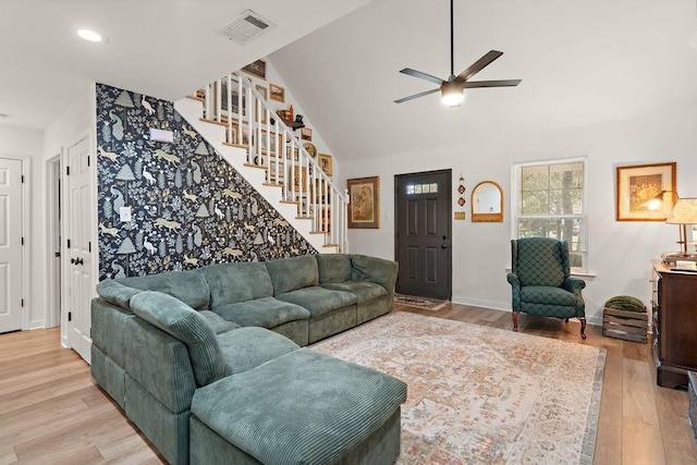 living room with ceiling fan, light wood-type flooring, and high vaulted ceiling