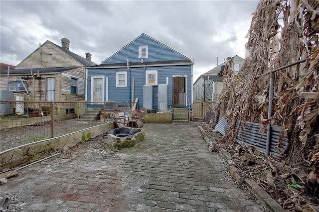 rear view of house with an outdoor fire pit