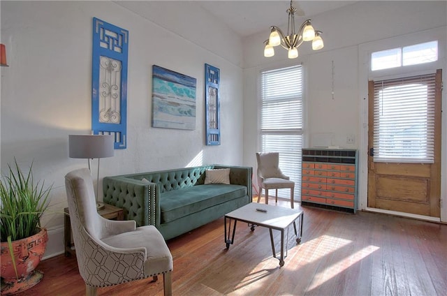 living room with dark hardwood / wood-style flooring, a chandelier, and a healthy amount of sunlight