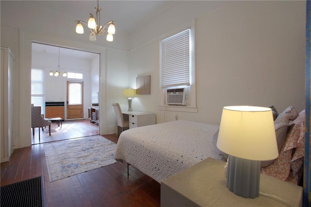 bedroom with cooling unit, a notable chandelier, and hardwood / wood-style flooring