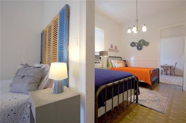 bedroom featuring an inviting chandelier and parquet floors