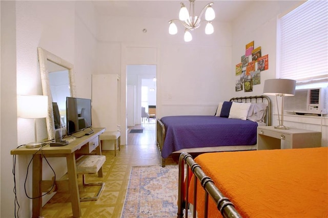 bedroom featuring light parquet flooring, a towering ceiling, cooling unit, and a notable chandelier