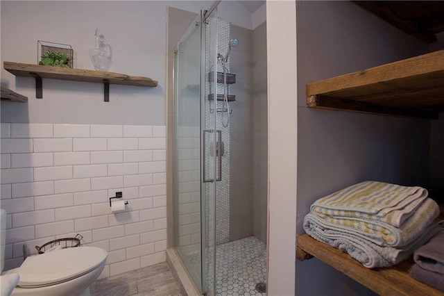 bathroom featuring tile walls, toilet, and walk in shower