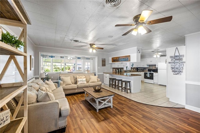 living room featuring light wood-type flooring and crown molding