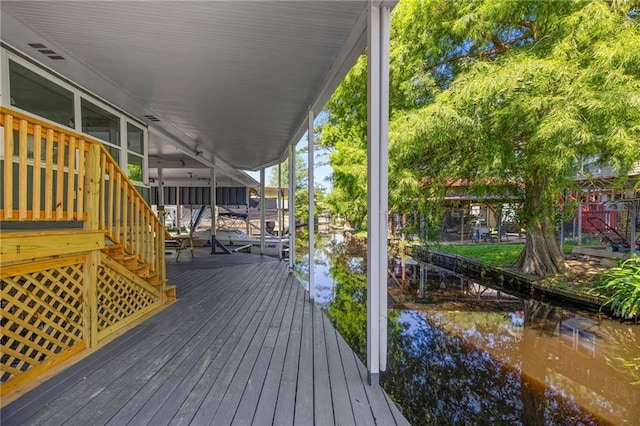 wooden terrace featuring a water view and a boat dock