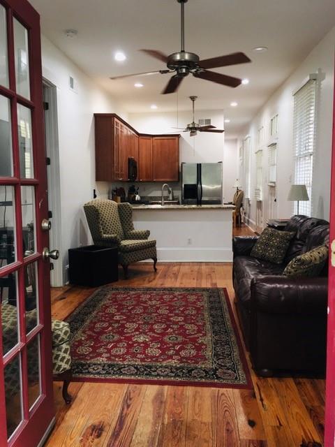 living room with hardwood / wood-style floors, ceiling fan, and sink