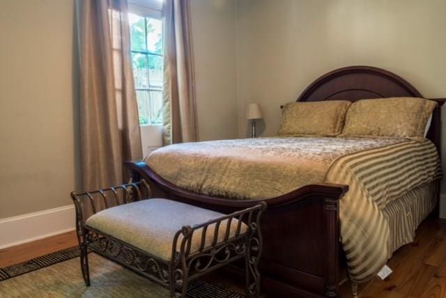 bedroom with dark hardwood / wood-style floors