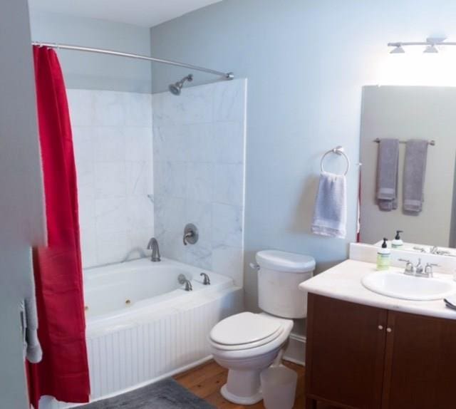 full bathroom with vanity, hardwood / wood-style flooring, toilet, and shower / bathtub combination with curtain