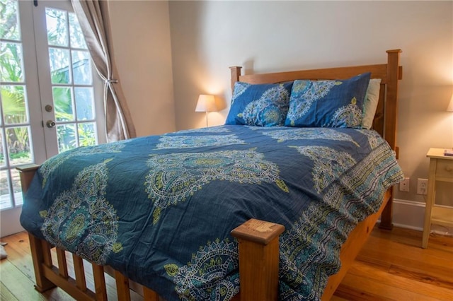 bedroom with multiple windows and light hardwood / wood-style flooring