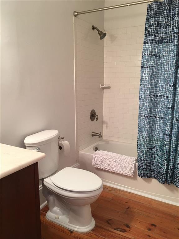 full bathroom with hardwood / wood-style flooring, vanity, toilet, and tiled shower / bath