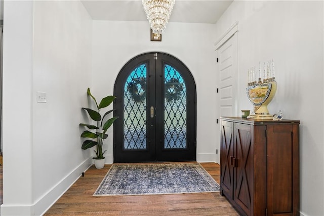 foyer entrance with french doors, a notable chandelier, and hardwood / wood-style floors