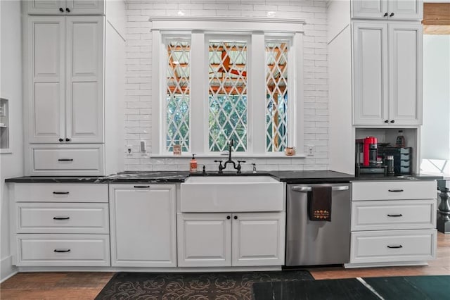 kitchen featuring tasteful backsplash, dishwasher, white cabinets, and sink