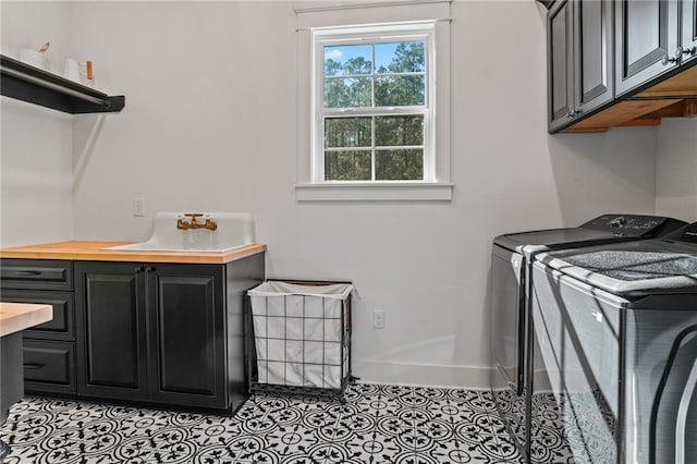 washroom featuring washer and dryer, cabinets, and light tile patterned flooring