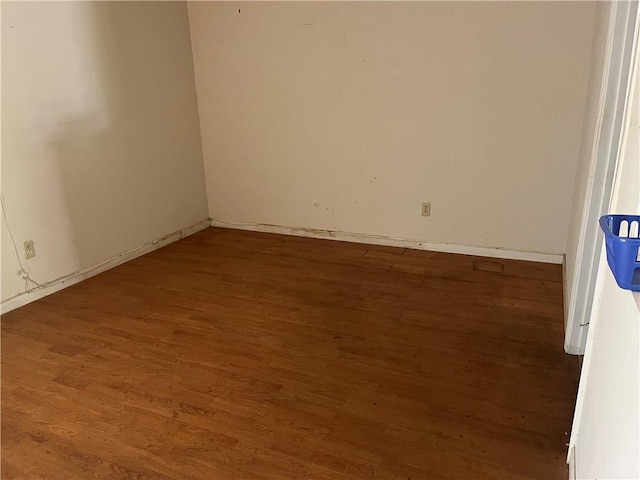 unfurnished room with dark wood-type flooring