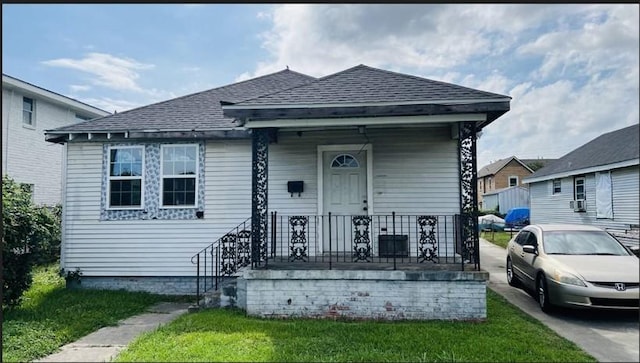 bungalow-style home with a porch and a front lawn