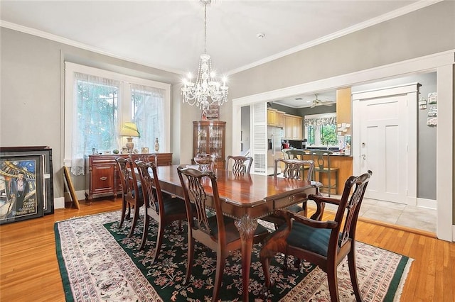 dining space featuring light wood-type flooring, ornamental molding, and a wealth of natural light