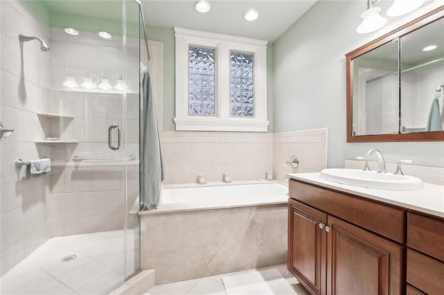 bathroom featuring tile patterned flooring, vanity, and shower with separate bathtub