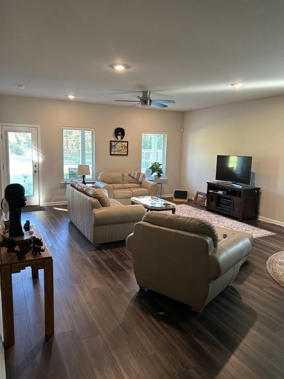 living room with ceiling fan and dark hardwood / wood-style flooring