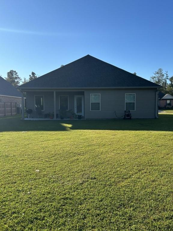 back of property featuring a lawn