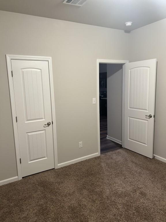 unfurnished bedroom featuring dark carpet