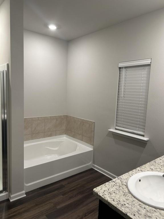 bathroom featuring a tub to relax in, hardwood / wood-style floors, and vanity