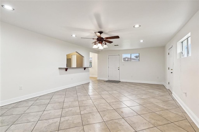 tiled spare room with ceiling fan and a healthy amount of sunlight