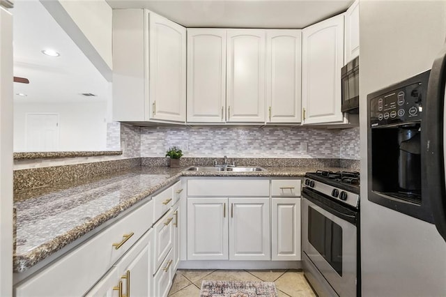 kitchen featuring backsplash, stainless steel gas range, sink, refrigerator with ice dispenser, and white cabinets