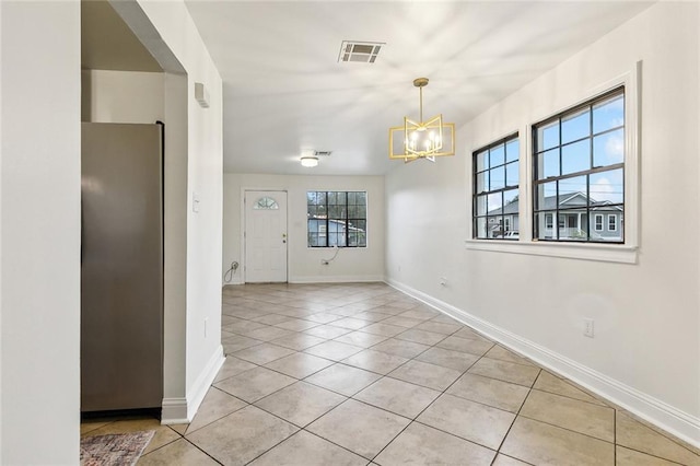 unfurnished dining area with light tile patterned floors and an inviting chandelier