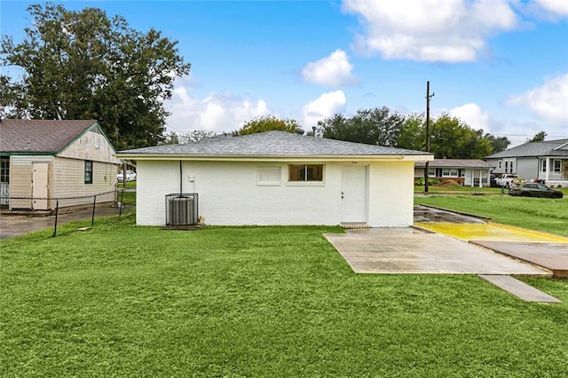 rear view of house with a yard and cooling unit