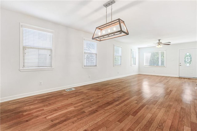 interior space with ceiling fan, plenty of natural light, and hardwood / wood-style flooring