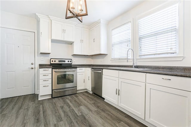 kitchen featuring appliances with stainless steel finishes, white cabinetry, dark wood-type flooring, and sink