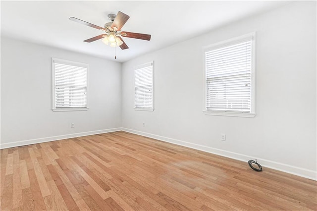 spare room featuring light hardwood / wood-style floors, ceiling fan, and a healthy amount of sunlight